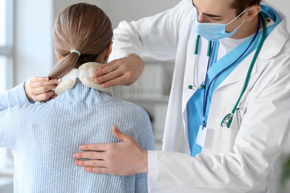 woman at doctor's office with bulging disc in her neck after a car accident